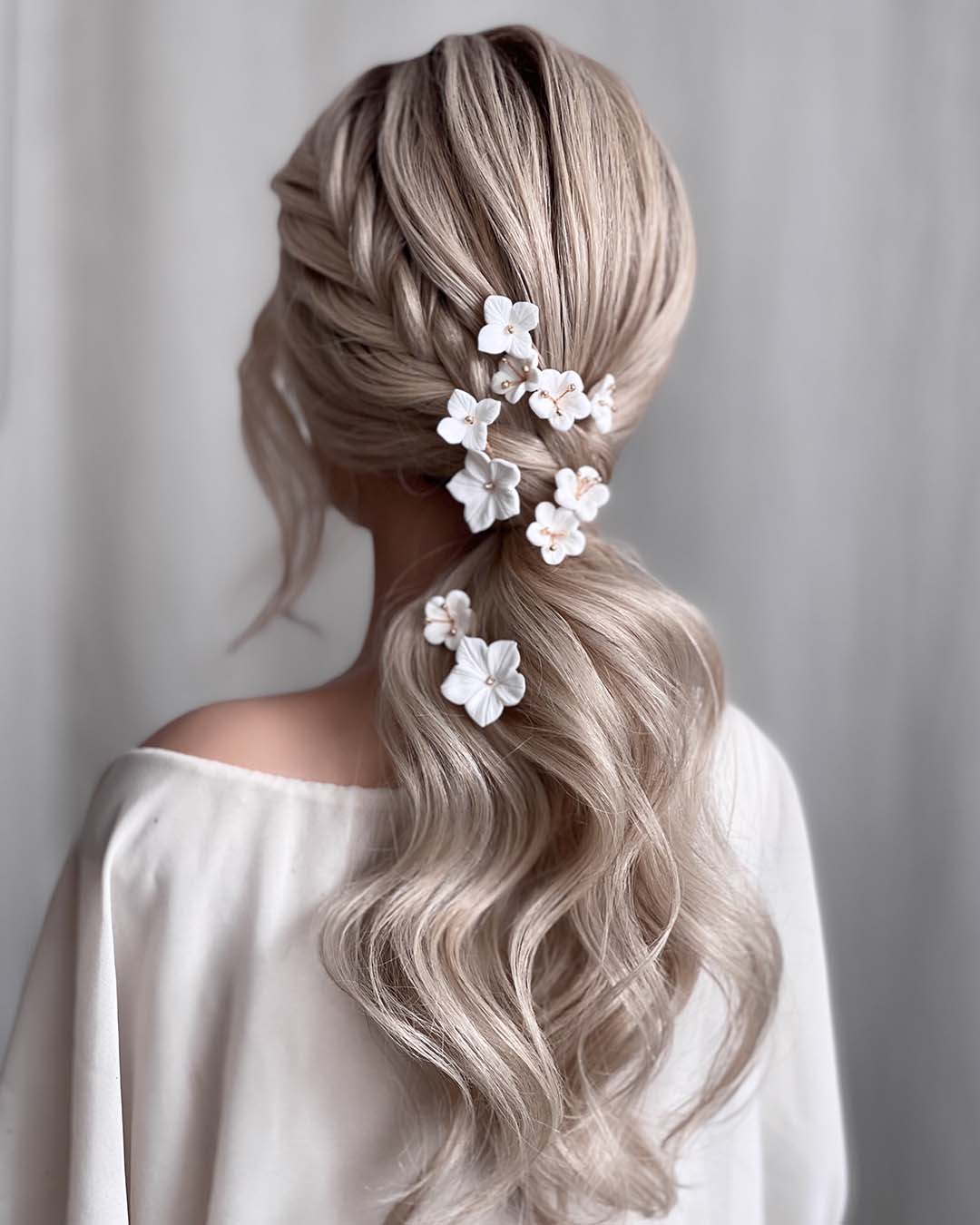 pony-tail-hairstyles-wedding-wavy-low-with-side-braid-white-flower-pins-kasia_fortuna